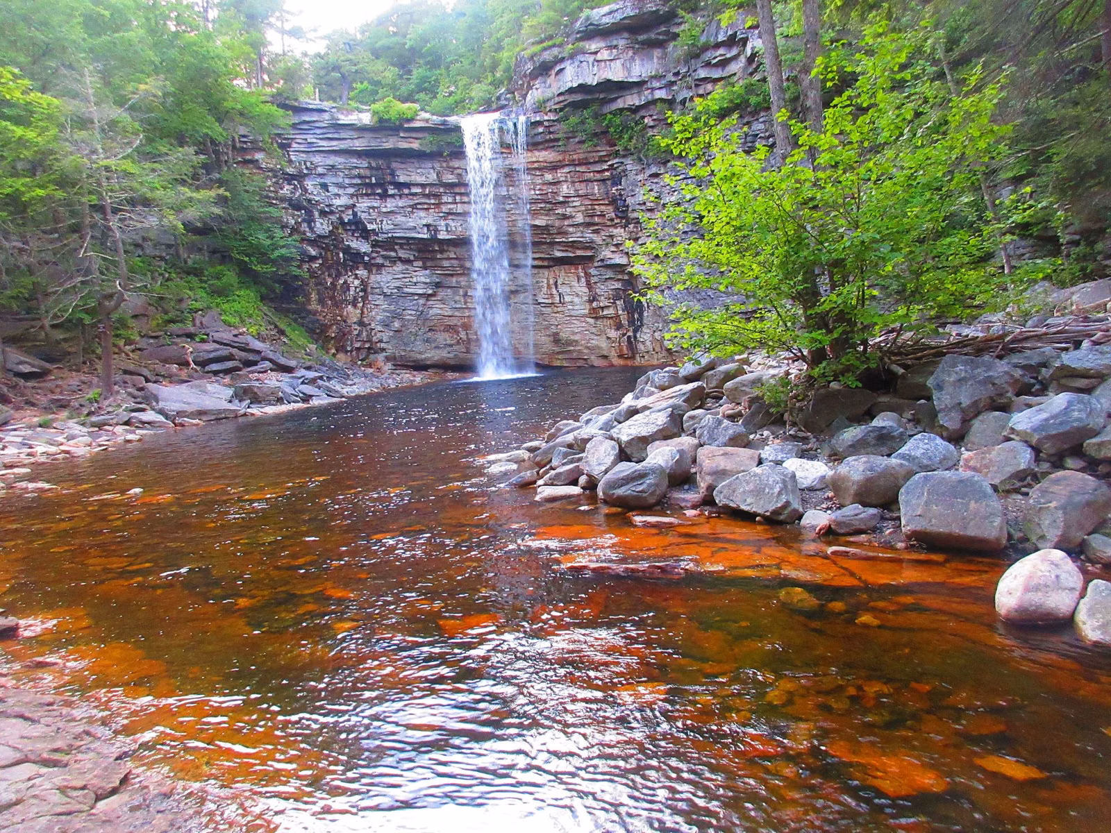 Awosting Falls pouring over a layered rock ledge into a tea-coloured pool at Minnewaska State Park Preserve